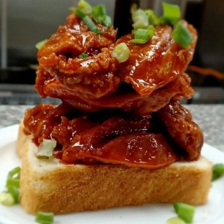 Hangover chicken wings glazed in sweet and spicy sauce with scallions, shown on Texas toast