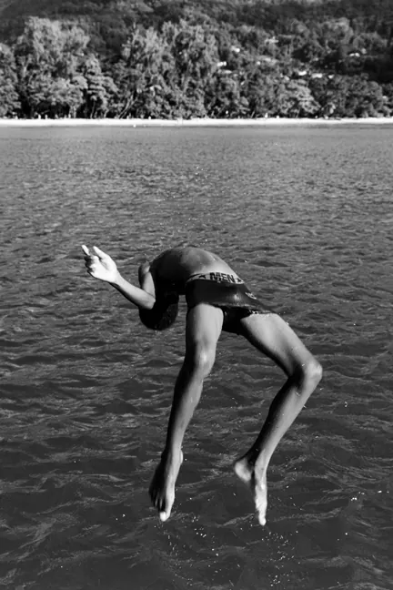 Photograph by Natasha Moustache: a figure arching backward into the sea.