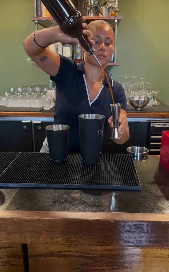 A bartender pouring a cocktail at the Parkway Social bar